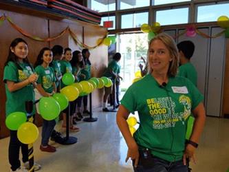 group with green shirts on with balloons doing an activity