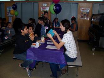 students eating together and smiling with a young adult 